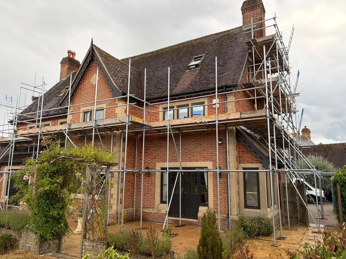 Wrap-around scaffold on a large gabled brick house