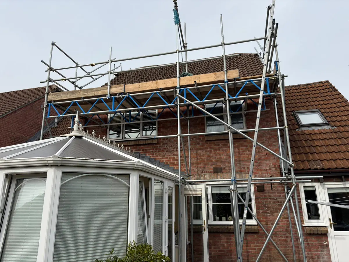 Scaffold carried over a conservatory on a beam