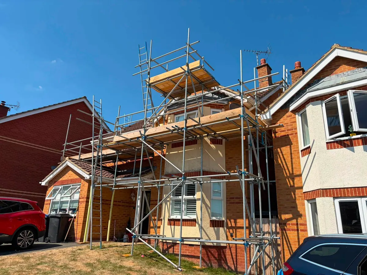 Scaffold around a bay-fronted brick house